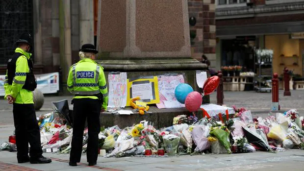 Dos policías británicos observan el altar improvisado en honor a las víctimas del atentado de Mánchester