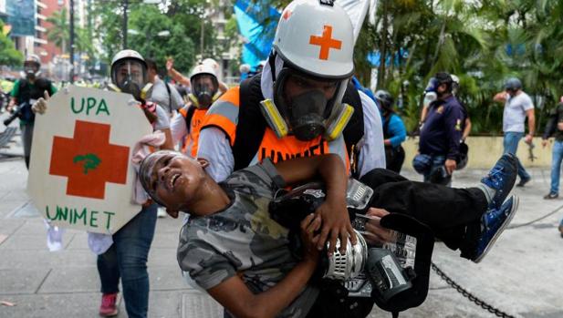Un equipo de emergencia traslada a un adolescente afectado por los gases lacrimógenos durante una protesta opositora el martes en Caracas