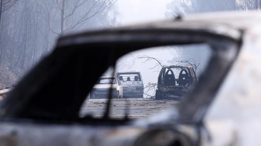 Coches calcinados en una carretera afectada por el fuego