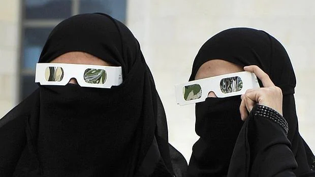 Dos mujeres saudíes observan un eclipse solar parcial en el Mar Rojo