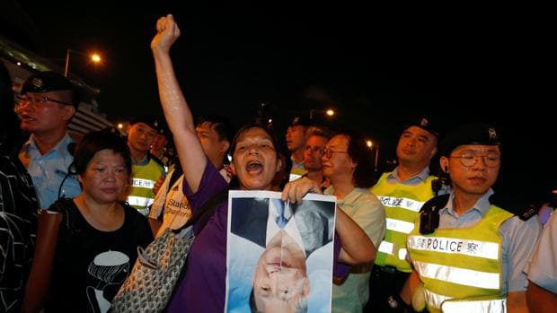 Manifestantes protestan rompiendo una foto del presidente chino, Xi Jinping