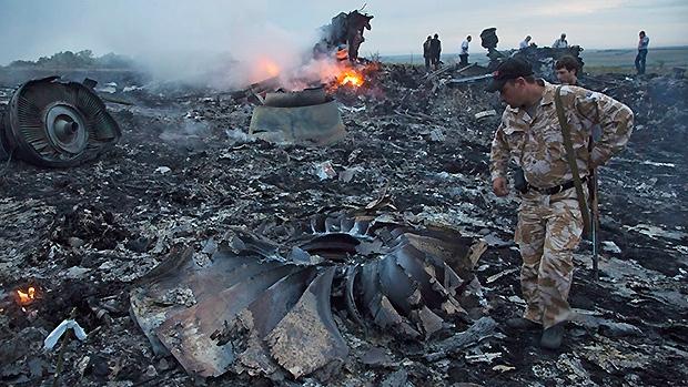 Un soldado inspecciona los restos del avión derribado en julio de 2014