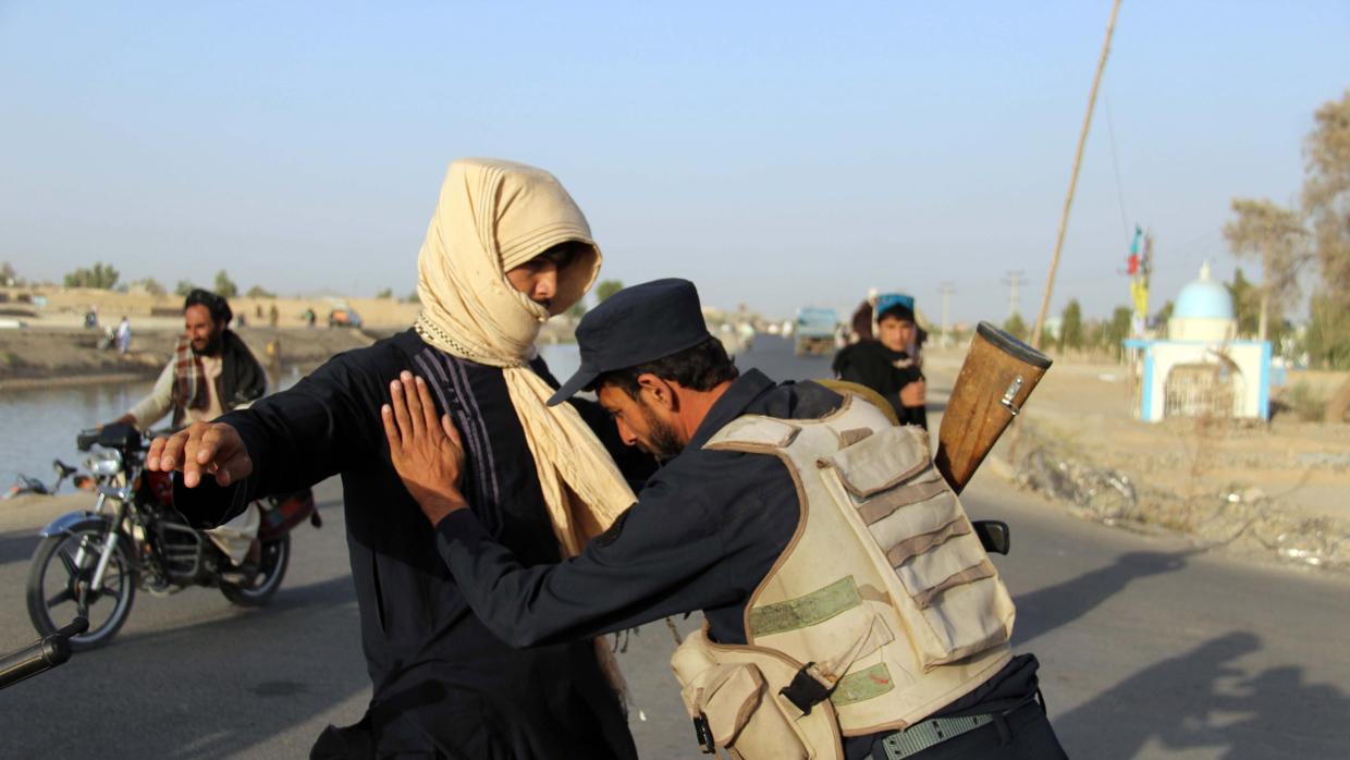 Un policía afgano registra a un civil en la región de Kandahar, una de las peligrosas de Afganistán