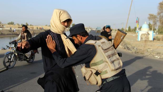Un policía afgano registra a un civil en la región de Kandahar, una de las peligrosas de Afganistán