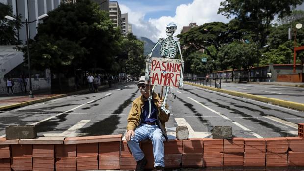 Un hombre protesta en una e las calles cortadas de Caracas