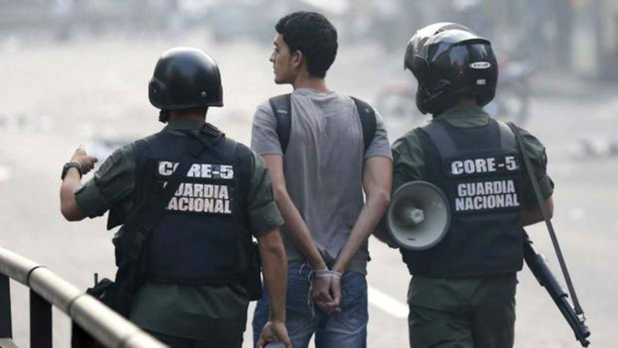 La Guardia Nacional Bolivariana (GNB) lleva detenido a un joven durante una protesta