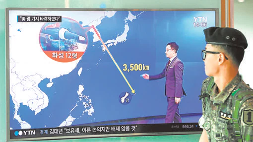 Un soldado surcoreano pasa junto a una pantalla en la que se puedever la distancia entre Pyongyang y la isla de Guam