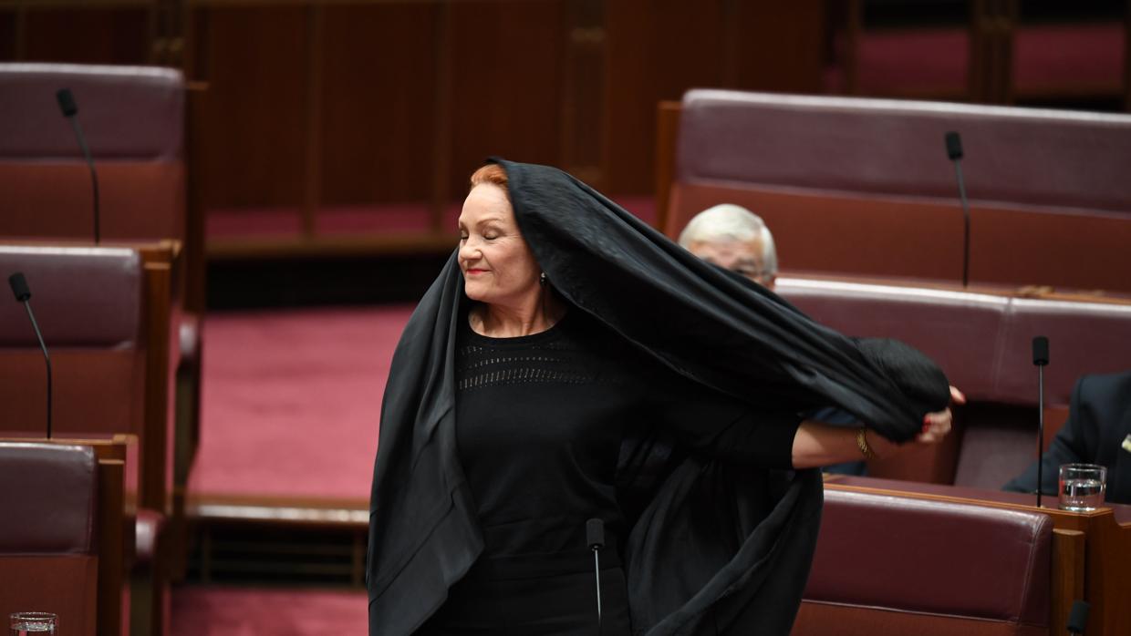 La senadora australiana Pauline Hanson, quitandose el burka antes de tomar la palabra