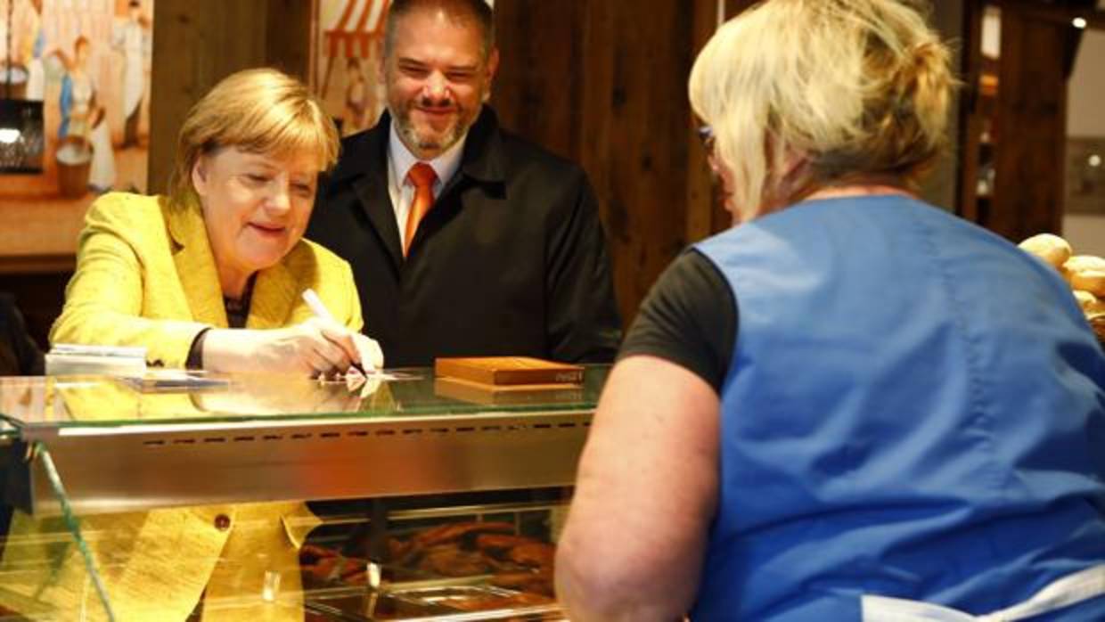 Merkel firma un autógrafo a una mujer que trabaja en una carnicería horas antes de que se celebren los comicios en Alemania