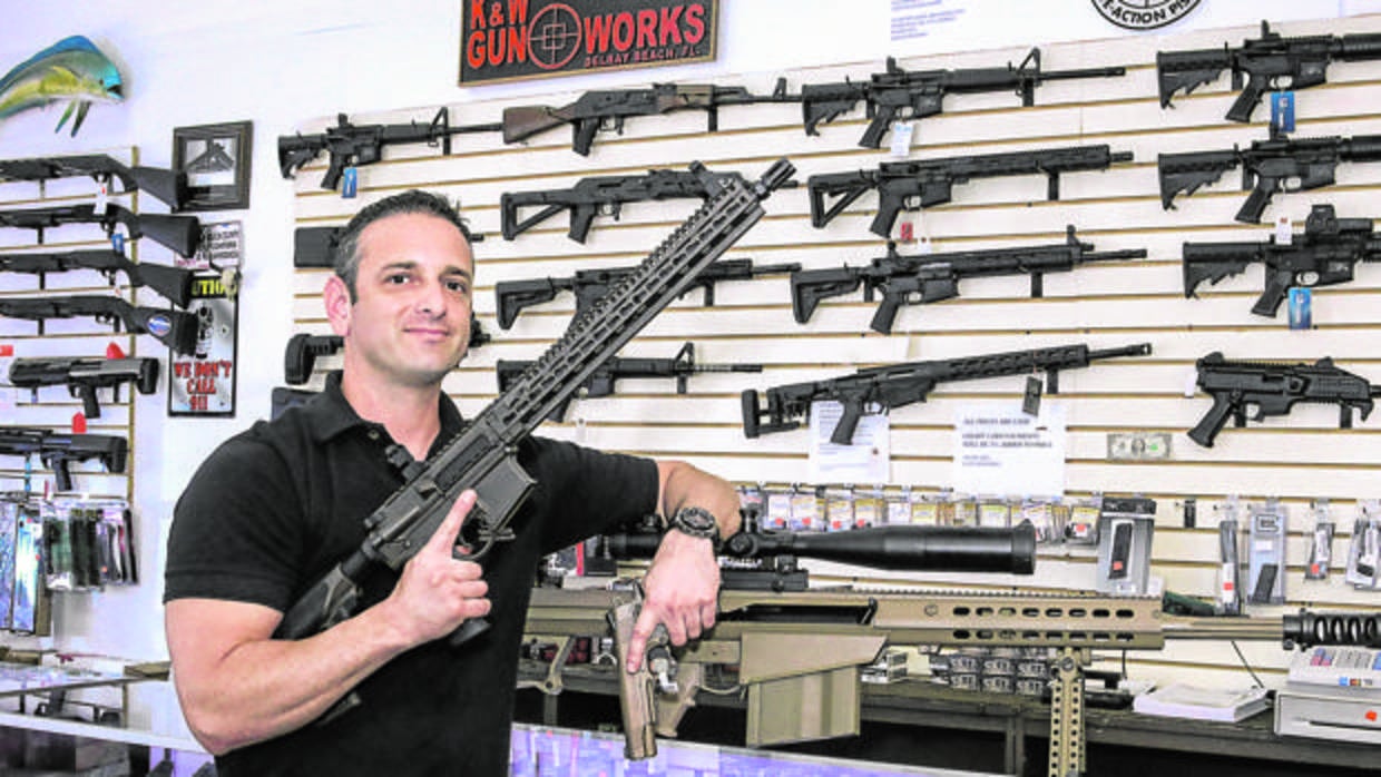 El propietario de una tienda de armas en Palm Beach, Florida, junto a su mercancía