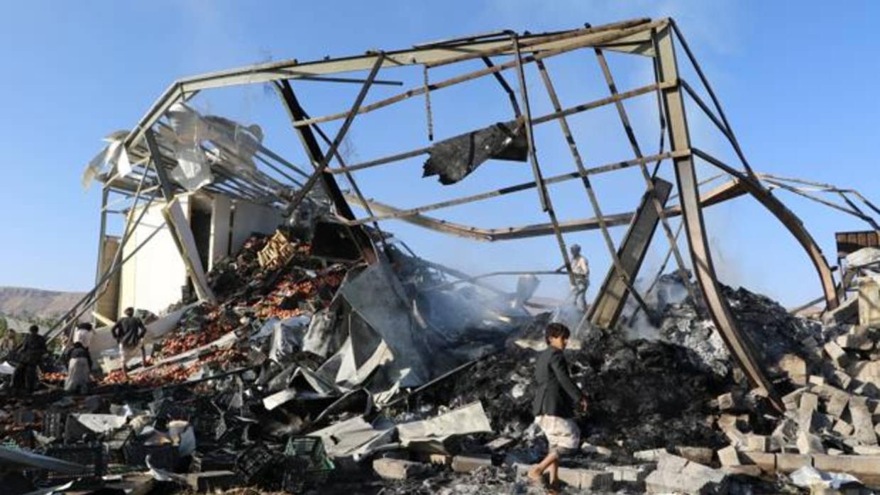 Ciudadanos tratan de trasladar la fruta de un edificio destruido por el ataque de la aviación saudí