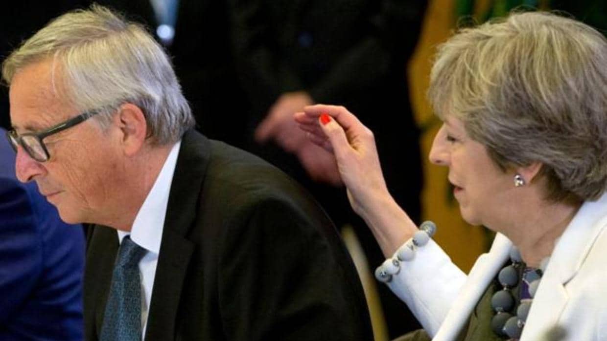 Theresa May pasa la mano por la espalda de Jean Claude Juncker el pasado día 20 en la cumbre europea