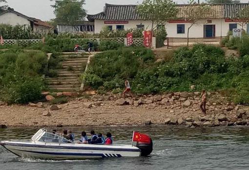 Las lanchas de turistas chinos se acercan a pocos metros de la orilla norcoreana en la frontera del río Yalu, cerca de Dandong