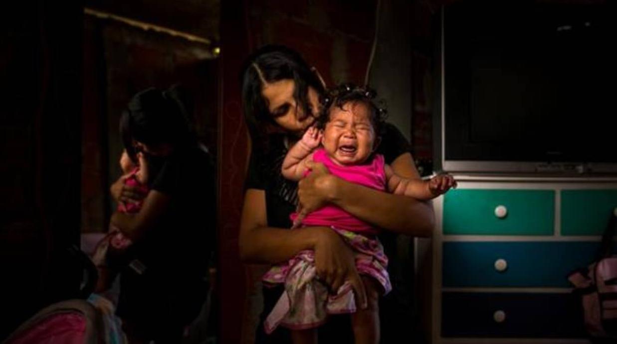 Una venezolana enferma de malaria con su hija, que padece una ceguera parcial como consecuencia de la enfermedad de su madre, en La Guaira (Venezuela), el pasado septiembre