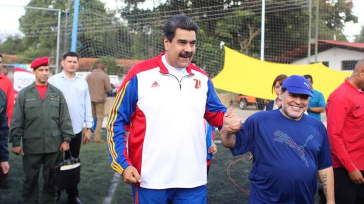 El presidente de Venezuela, Nicolás Maduro (i), mientras habla con Diego Armando Maradona