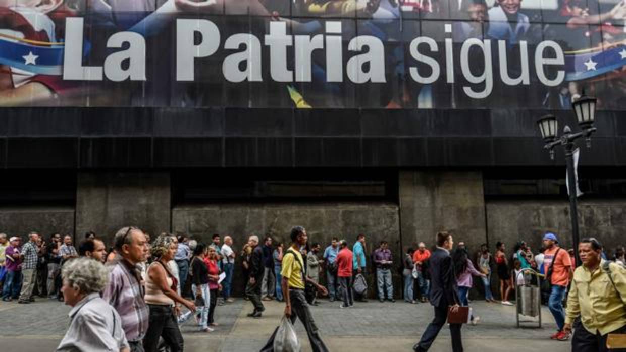 Una larga cola de venezolanos espera para poder retirar dinero de un cajero