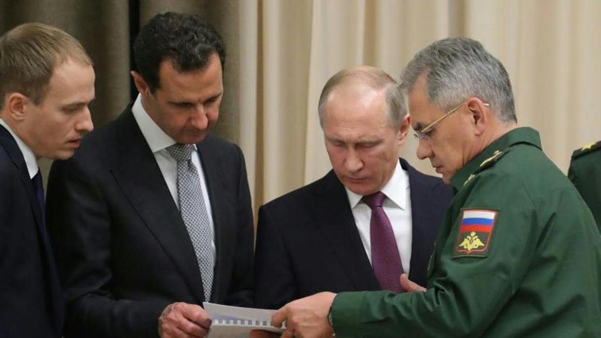Vladimir Putin (c)y Bashar al Assad, en presencia del ministro de Defensa ruso, Sergei Shoigu, este lunes en Sochi (Rusia)