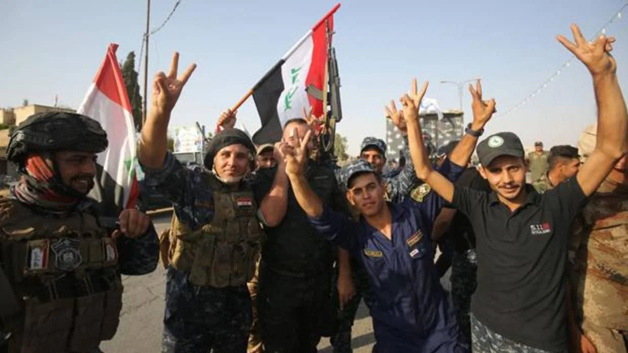 Miembros de la policía federal de Irak hacen el signo de la victoria tras la toma de Mosul el pasado julio