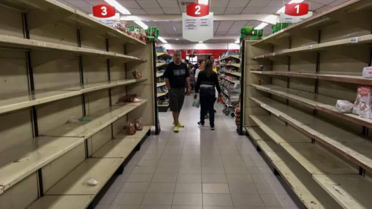 Varias personas buscan productos en un supermercado de Caracas