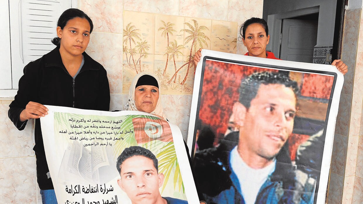 Manoubia Bouazizi (C) y sus hijas muestran carteles del joven Mohamed