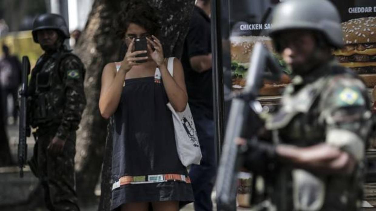 Una mujer toma fotos de los militares este sábado, primer día de la Fuerzas Armadas en Río de Janeiro