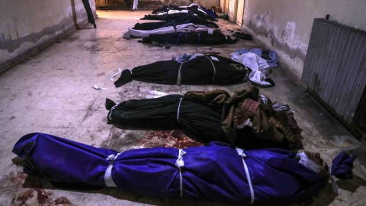 Cadáveres cubiertos con mantas permanecen en una morgue de Duma en Siria