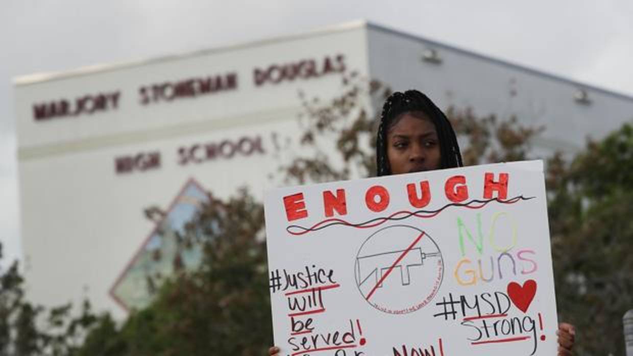 Una estudiante sujeta un cartel de protesta frente a la escuela de Parkland donde se produjo la matanza
