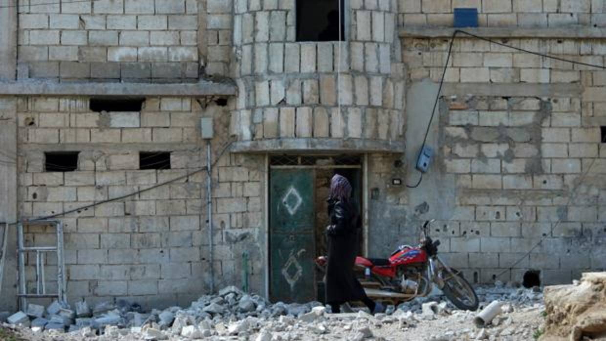 Una mujer inspecciona los destrozos tras una bomba en Idlib (Siria) este lunes