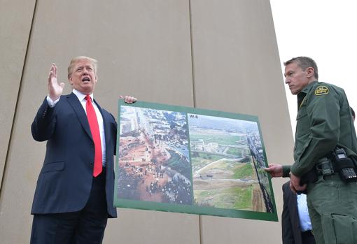 Trump sostiene una foto del antes y el después de la frontera de San Diegp con México