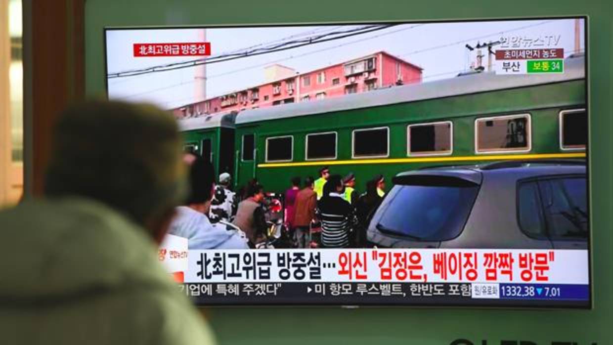 Un hombre ve unos informativos de televisión sobre una presunta visita a China del líder norcoreano Kim Jong Un