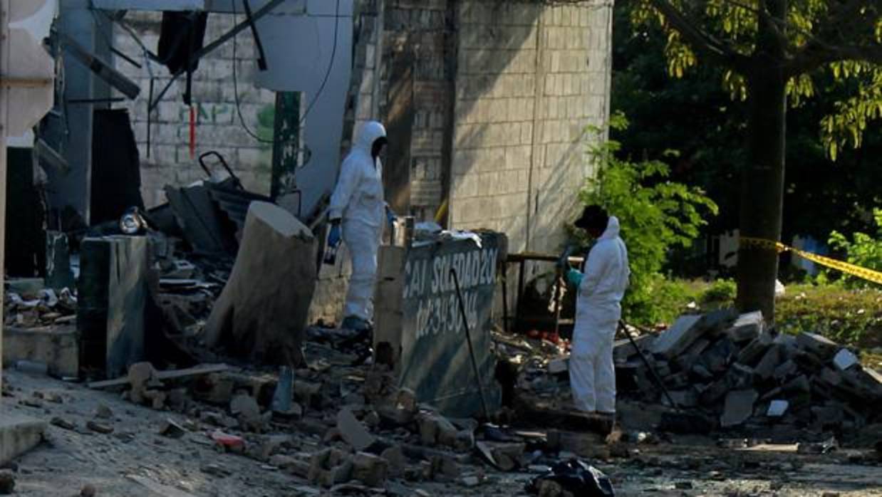 Fotografía de archivo de investigadores de la Policía colombiana revisando el lugar donde explotó un artefacto el pasado 28 de enero, en Barranquilla
