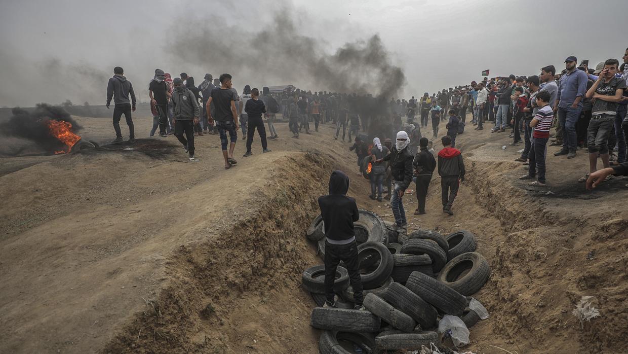 Paestinos queman neumáticos durante los enfrentamientos cerca de la frontera de Israel