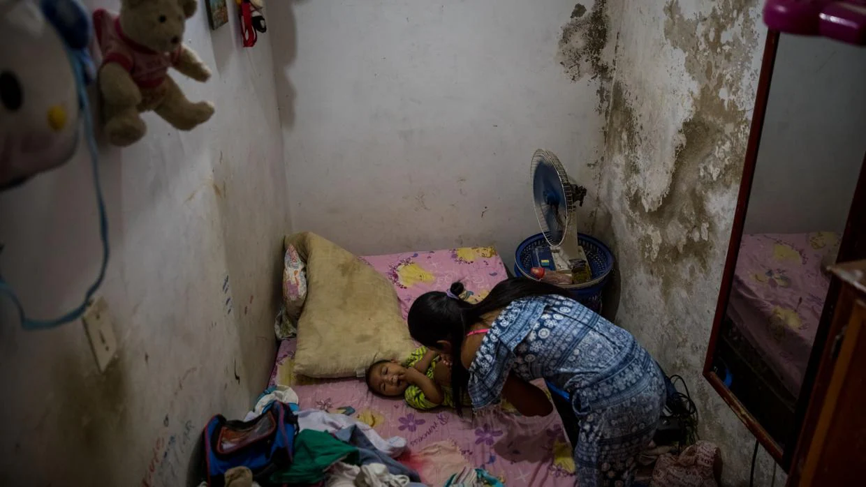 Una madre cuida a su hija que tsufre de malaria