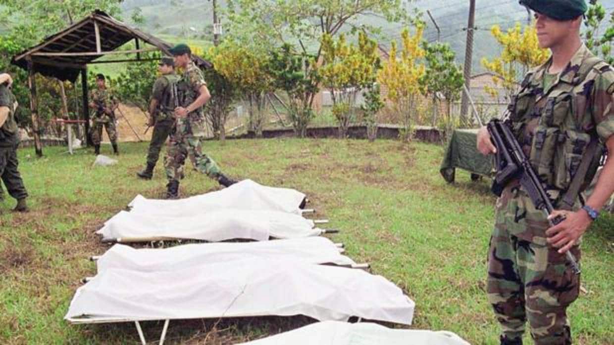 Foto archivo de un soldado frente a los cuerpos de víctimas de la guerrilla en Colombia