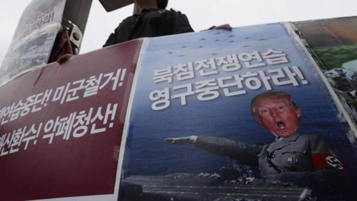 Un manifestante surcoreano sostiene una pancarta que dice "¡Alto! Ejercicios aéreos de Max Thunder"