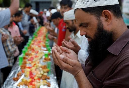 Un comerciante reza antes de tomar el Iftar, el desayuno de Ramadán, en Bombay (India)