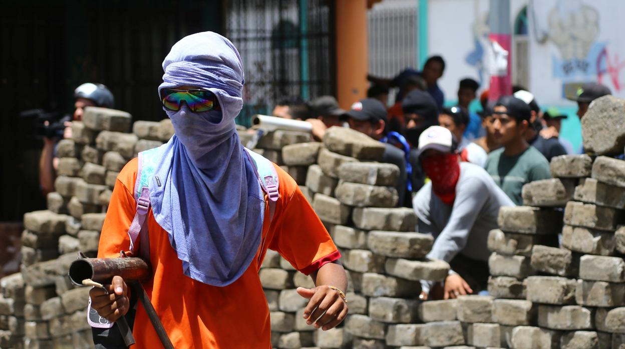 Un manifestante enmascarado se enfrenta contra la policia en una protesta contra el presidente Ortega en Masaya