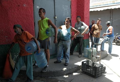 Ciudadanos hacen fila para llenar los bidones en la fábrica de hielo
