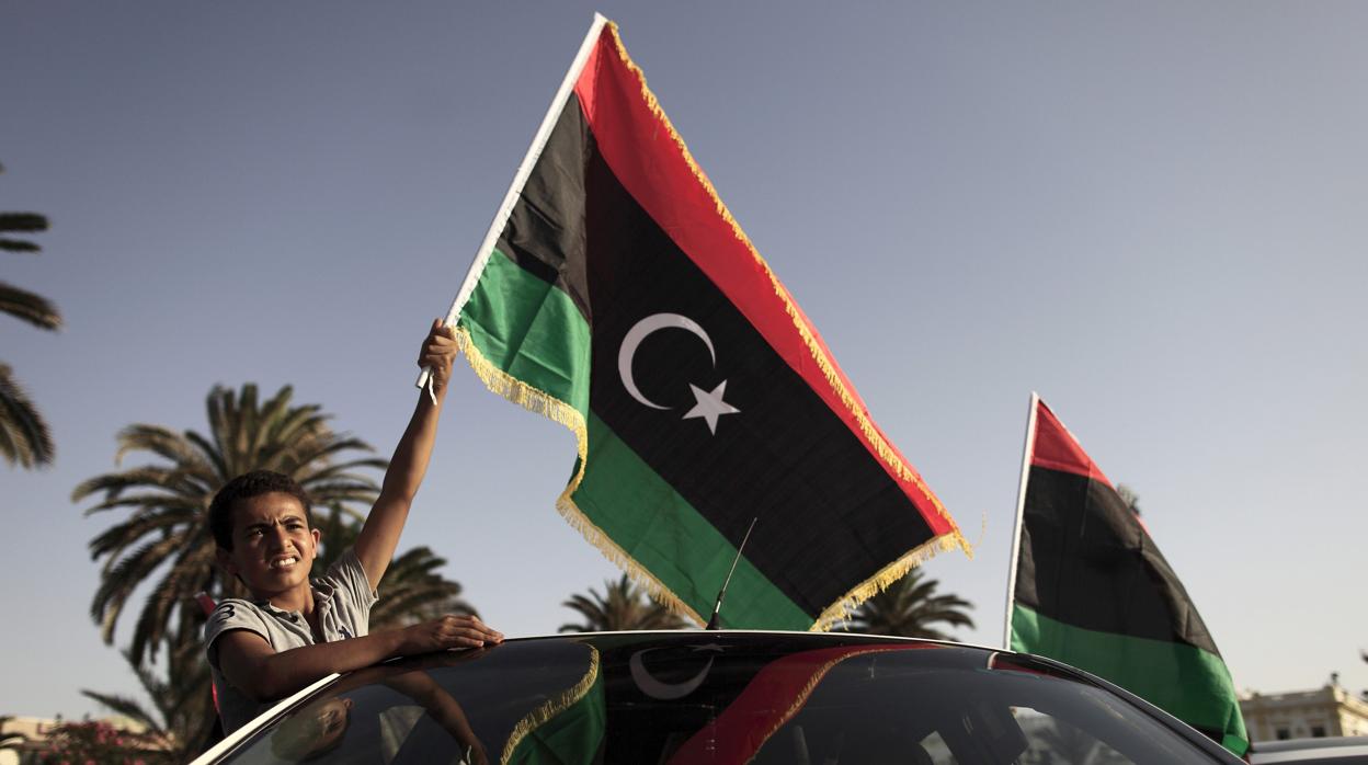 Un joven portando la bandera de Libia en Trípoli