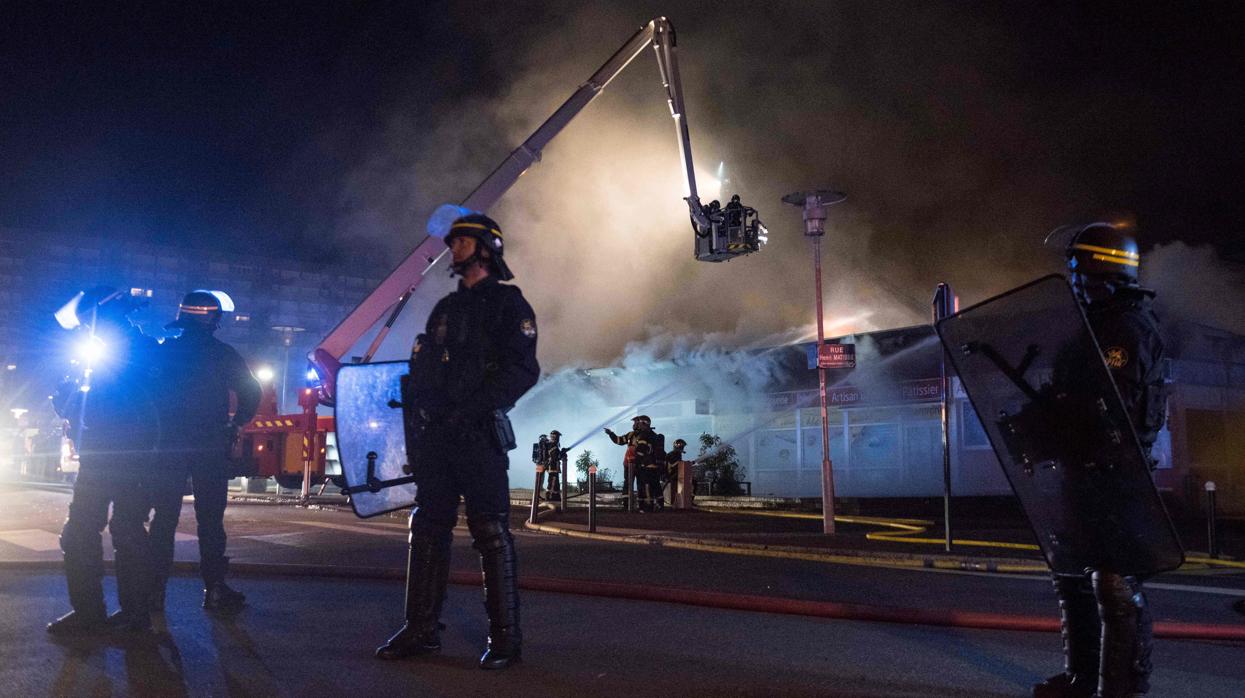 Policías anti disturbios vigilan una calle de Nantes mientras actúan los bomberos