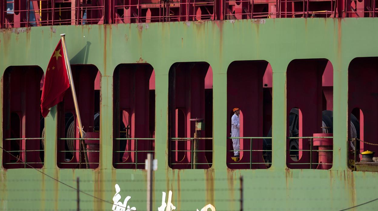 Un hombre permanece de pie en la cubierta de un carguero chino en Hong Kong