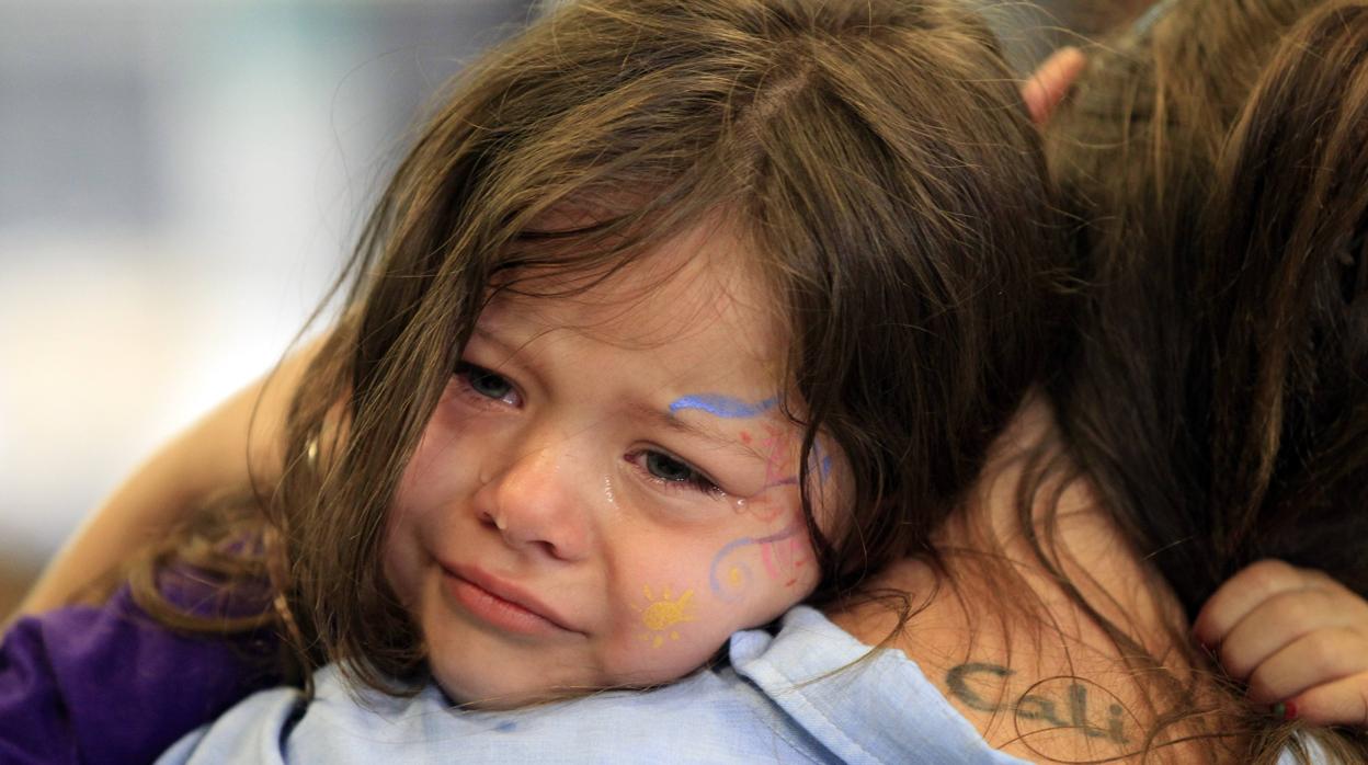 Foto archivo una niña abraza a su madre en California