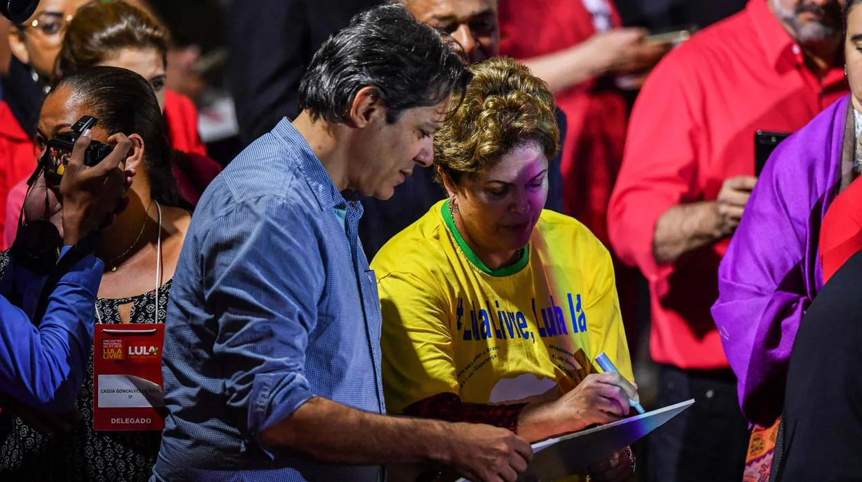El ex alcalde de Sao Paulo y miembro del Partido de los Trabajadores (PT) Fernando Haddad (L) escucha a la ex presidenta brasileña Dilma Rousseff