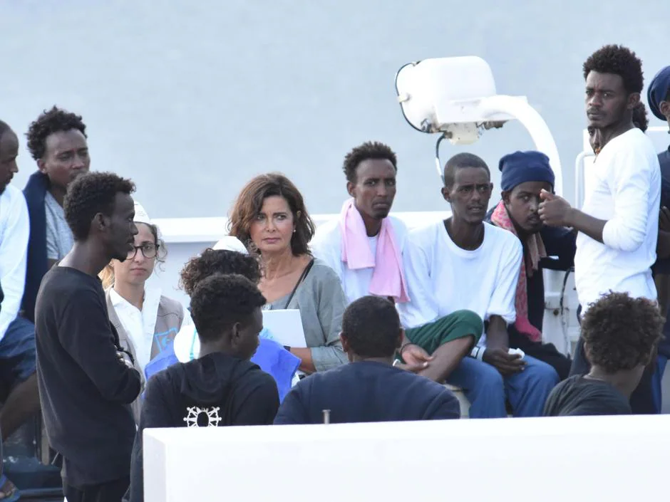 La expresidenta de la Cámara Baja italiana Laura Boldrini (c) conversa con inmigrantes a bordo del Diciotti