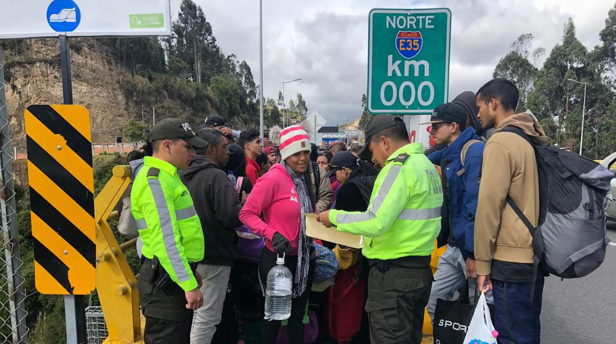 Policías ecuatorianos controlan una fila de emigrantes venezolanos en Ecuador