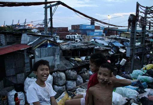 Unos niños juegan sobre montañas de basura en el arrabal de chabolas de Smokey Mountain, en Manila