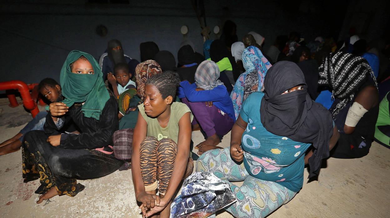 Migrantes mientras esperan en la base naval en Trípoli