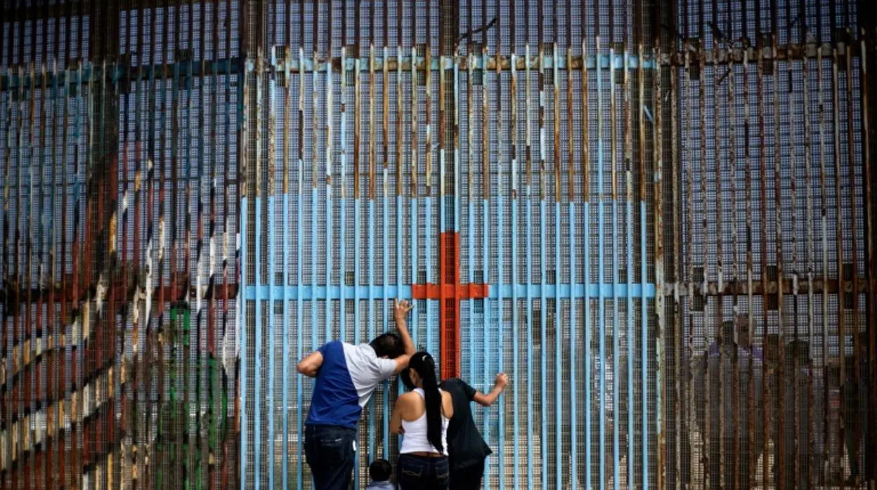 Una familia mexicana habla con sus parientes, al otro lado del muro en Tijuana
