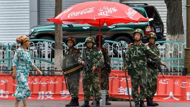 Una tropa de soldados chinos patrullapor una calle de un barrio uigur en Urumqi