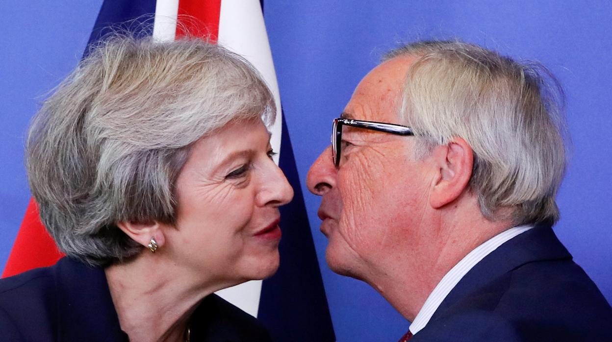 La primera ministra británica, Theresa May, y el presidente de la Comisión Europea, Jean-Claude Juncker, se saludan antes del Consejo Europeo